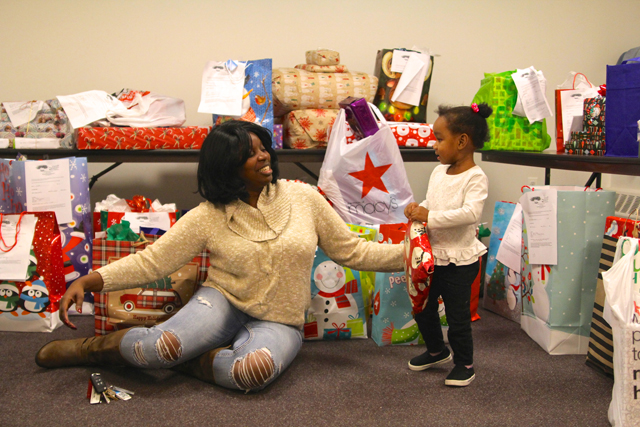 The Butterfly Effect Project founder Tijuana Fulford and Taliah, 2, organize Christmas gifts donated by Teachers Federal Credit Union.