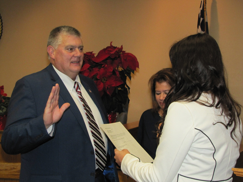 Councilman Tim Hubbard is sworn into office Friday by his daughter, Meaghan Howard.