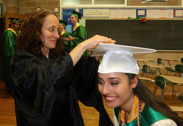 Juliet Fusco of Riverhead bends down a little to have teacher Monique Hernandez add her tassel. (Credit: Barbaraellen Koch)