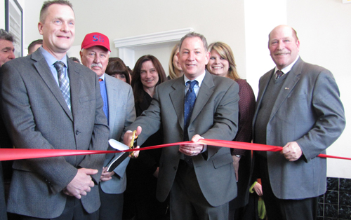 Michael Butler (center) cuts the ribbon Thursday at the E. Main St. apartment complex. (Credit: Tim Gannon)