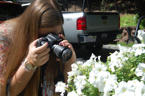 Amanda de Lauzon takes a picture of flowers. She's had several still images featured on Jones Soda bottles. (Credit: Nicole Smith)