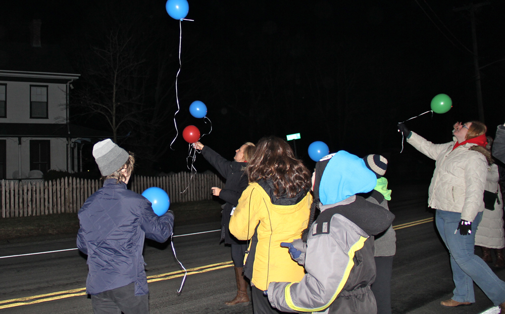 Jennifer Callaghan lets go of a red balloon in memory of her husband James. (Credit: Carrie Miller)
