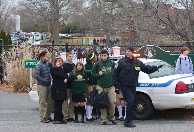 A Riverhead police officer guides students at Mercy following a bomb threat Wednesday. (Credit: Barbaraellen Koch)