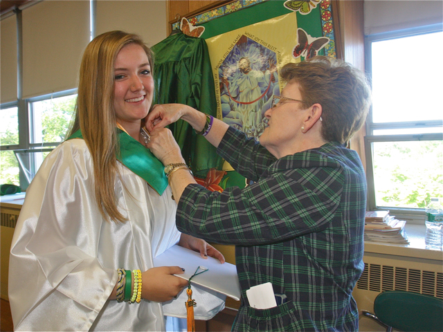 Religion teacher Michele Nappi helps Savannah Pavelchak get ready. (Credit: Barbaraellen Koch)