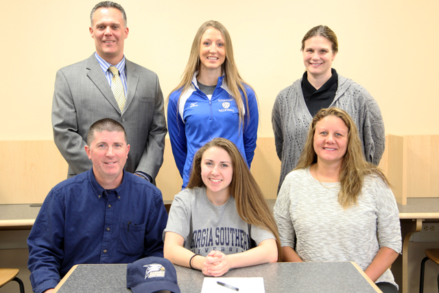 Joscelin Morrow was joined for a signing ceremony by her parents John (left) and Nancy (right). High School principal Charles Regan,  varsity coach Amy Greene and guidance counselor Suzzane Maurino joined her as well. (Credit: Riverhead Schools)