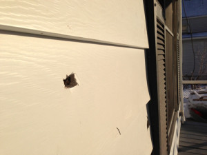 PAUL SQUIRE PHOTO | Three bullet holes could be seen in the front siding of the house.