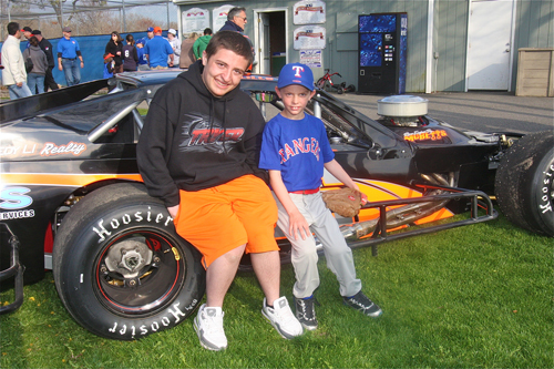 Teenage race car driver Vincent Biondolillo posed with kids at Stotzy Park last Friday during Riverhead Little League's Opening Day. (Credit: Barbarallen Koch)
