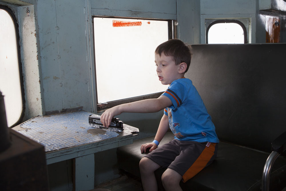 Pat Buffolino, 4, of Huntington plays with his toy train aboard a LIRR caboose. (Credit: Katharine Schroeder)