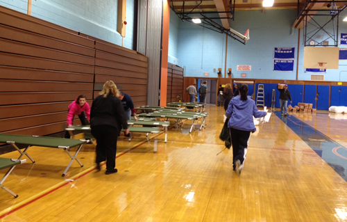 BETH YOUNG PHOTO | Setting up the storm shelter in Riverhead High School Sunday.