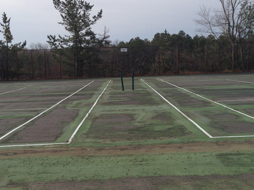 A view of two of Shoreham's tennis courts last spring, which have become unplayable after years of neglect. A proposed $48.5 million construction project would repair the courts. (Credit: Joe Werkmeister, file)