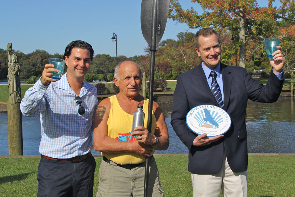 Aaron Virgin, VP of Group for the East End; Jim Dreeben, owner of Peconic Paddler; and Riverhead Supervisor Sean Walter down by the Peconic River on Friday morning. (Credit: Carrie Miller)