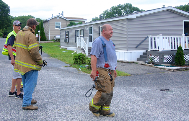 Riverhead Fire Department Chief Kevin Brooks (right) and other firemen at the scene.