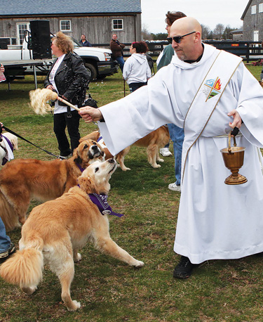 Deacon Michael Bonocore from St. Isidore R.C. Church in Riverhead blesses the animals at the start of Sunday afternoon's Bark for Life walk at Martha Clara Vineyard. The event was a fundraiser for the American Cancer Society's Relay for Life.